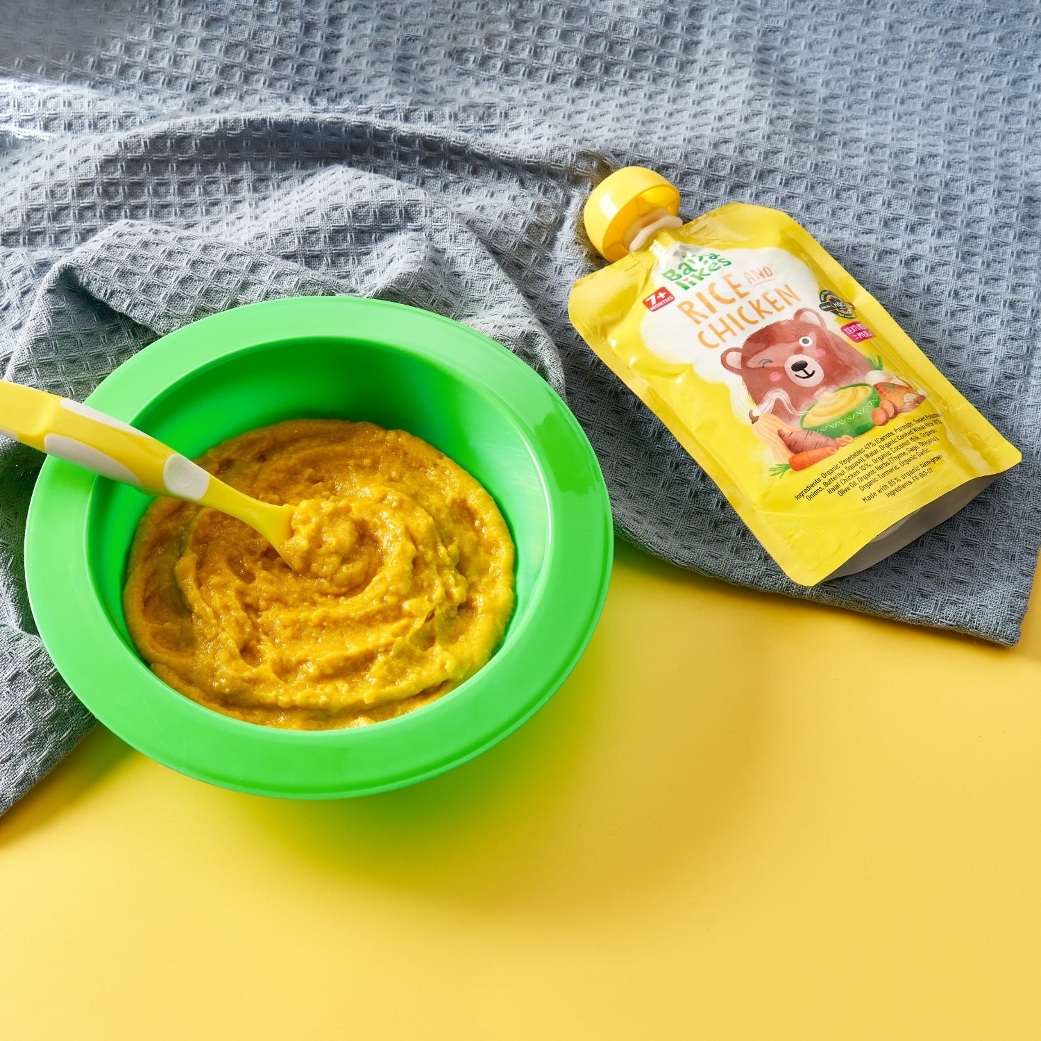 Lifestyle image of Baby Likes Rice and Chicken baby food served in a bowl beside its branded pouch — a wholesome, halal-certified meal for weaning babies