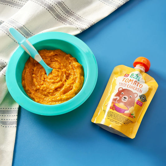 Bowl of Baby Likes Tomato Pasta Chicken baby puree beside its branded pouch, highlighting a wholesome, ready-to-eat meal for babies